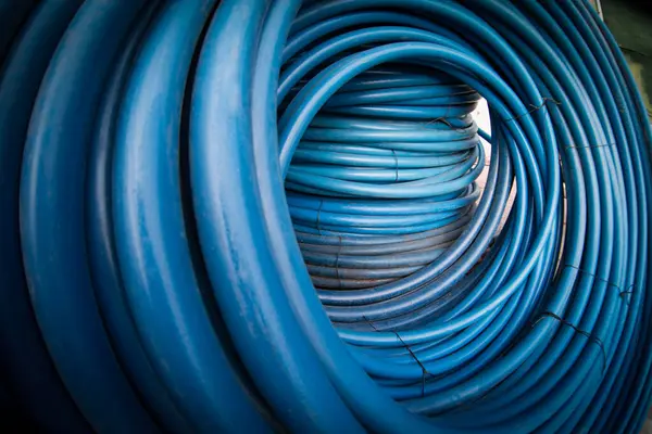 blue plastic hoses twisted into rings. blue PVC hoses. Blue plastic pipes for water supply system, close-up