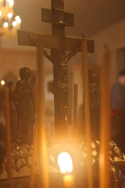 燃えるろうそくからの単一の炎か光はクリスマス 葬儀または追悼のための教会のテーブルの暗い背景に対してオレンジ色のろうそくに輝きます — ストック写真