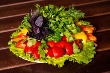 Tabakta taze domates salatası, kırmızı dolmalık biber ve bitkiler olsun. 