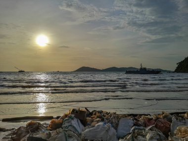 Tayland Körfezi ve Samet Adaları 'nın ortasında, Rayong Denizi' nin ortasındaki ham petrol sızıntısı. Personel ve gönüllüler kumsaldaki petrol sızıntılarını temizlemeye yardım ediyor, yağmur yağıyor.