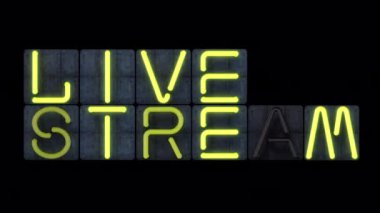 Parlak sarı yanıp sönen cam neon harfli neon renkli bir 'Live STREAM' manşeti.. 