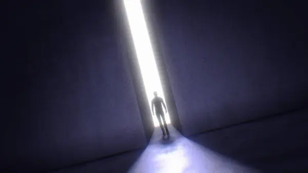 Karanlık bir sahnede, parlak bir ışığa doğru yürüyen bir adam görüyoruz. Büyük, taştan bir duvarın içinden yüksekten iniyor..