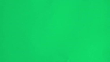 Tam ekran yeşil kağıt, ortasından yırtılan bir delikle dur hareketi tarzında patladı..
