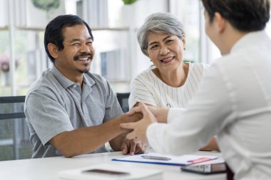Sağlıklı, keyifli, gülümseyen, emeklilikten sonra hayat sigortası personeliyle konuşan Asyalı yaşlılar..