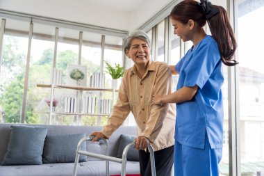 Evde yalnız yaşayan yaşlı kadınların sağlık ve fizik tedavilerini izleyen hemşireler Asyalı kadınlara bakıyor. baston üzerinde yürüyerek ya da kas kullanarak.