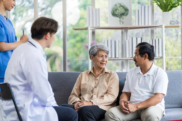 Asyalı Yaşlı Erkek Kadınlar Evlerinde Sağlıklarını Kontrol Etmeye Gelen Doktorlarla — Stok fotoğraf