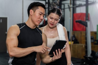 Asyalı erkek ve kadınların güçlü bir vücudu, sağlıklı ve egzersiz yapmaya bayılıyorlar. Spor salonunda birlikte egzersiz yapıyorlar. Eğleniyorlar..