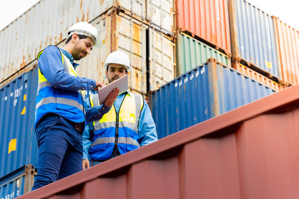Два инженера-мужчины в контейнерной транспортной компании Consulting, чтобы проверить заказ для контейнера, который несет ответственность
