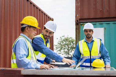 Konteynır taşıma şirketinde çalışan grup erkek mühendisleri sorumlu konteynır siparişini kontrol etmek için danışmanlık yapıyorlar.
