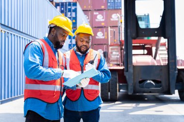 Konteynır nakliye şirketinde iki erkek mühendis sorumlu konteynır siparişini kontrol etmek için danışmanlık yapıyor.