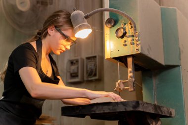 Bir kadın marangozun portresi, mobilya fabrikasında mobilya yapmak için aletler ya da makineler kullanıyor, matkap değil. modern araçlarla