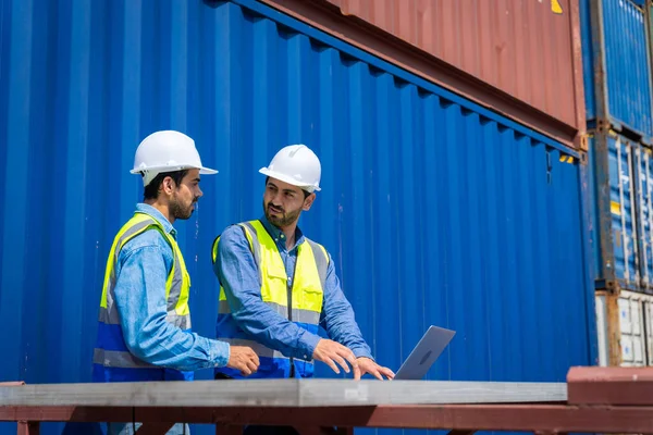 stock image Two male engineers in a container shipping company Consulting to check the order for the container that is responsible