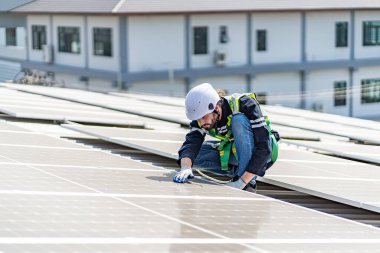 Male engineer installing or checking the working condition of solar panels on the roof or at the height of the factory for saving electricity was broken to use renewable energy from the sun