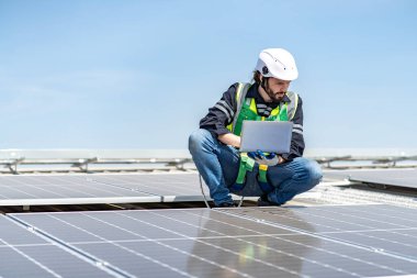 Male engineer installing or checking the working condition of solar panels on the roof or at the height of the factory for saving electricity was broken to use renewable energy from the sun