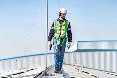 Male engineer installing or checking the working condition of solar panels on the roof or at the height of the factory for saving electricity was broken to use renewable energy from the sun