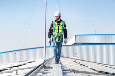Male engineer installing or checking the working condition of solar panels on the roof or at the height of the factory for saving electricity was broken to use renewable energy from the sun