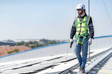 Male engineer installing or checking the working condition of solar panels on the roof or at the height of the factory for saving electricity was broken to use renewable energy from the sun