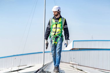 Male engineer installing or checking the working condition of solar panels on the roof or at the height of the factory for saving electricity was broken to use renewable energy from the sun