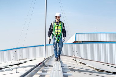 Male engineer installing or checking the working condition of solar panels on the roof or at the height of the factory for saving electricity was broken to use renewable energy from the sun