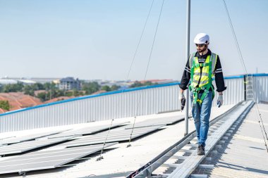 Male engineer installing or checking the working condition of solar panels on the roof or at the height of the factory for saving electricity was broken to use renewable energy from the sun