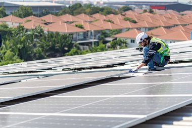 Male engineer installing or checking the working condition of solar panels on the roof or at the height of the factory for saving electricity was broken to use renewable energy from the sun