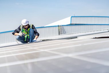 Male engineer installing or checking the working condition of solar panels on the roof or at the height of the factory for saving electricity was broken to use renewable energy from the sun