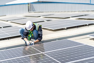 Male engineer installing or checking the working condition of solar panels on the roof or at the height of the factory for saving electricity was broken to use renewable energy from the sun