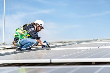 Male engineer installing or checking the working condition of solar panels on the roof or at the height of the factory for saving electricity was broken to use renewable energy from the sun