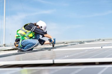 Male engineer installing or checking the working condition of solar panels on the roof or at the height of the factory for saving electricity was broken to use renewable energy from the sun