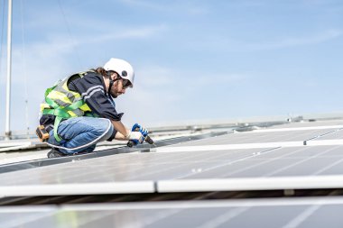 Male engineer installing or checking the working condition of solar panels on the roof or at the height of the factory for saving electricity was broken to use renewable energy from the sun