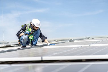 Male engineer installing or checking the working condition of solar panels on the roof or at the height of the factory for saving electricity was broken to use renewable energy from the sun
