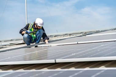 Male engineer installing or checking the working condition of solar panels on the roof or at the height of the factory for saving electricity was broken to use renewable energy from the sun