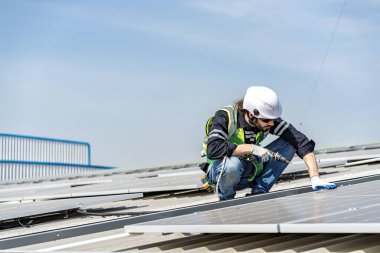Male engineer installing or checking the working condition of solar panels on the roof or at the height of the factory for saving electricity was broken to use renewable energy from the sun