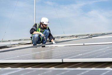 Male engineer installing or checking the working condition of solar panels on the roof or at the height of the factory for saving electricity was broken to use renewable energy from the sun