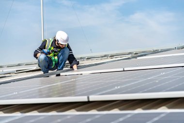 Male engineer installing or checking the working condition of solar panels on the roof or at the height of the factory for saving electricity was broken to use renewable energy from the sun