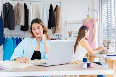 Küçük işletmeler, KOBİ 'de birlikte çalışan iki Asyalı kadın müşteriler için terzilik tasarımı yapıyor. İkisi de büyük tasarımcılar gibi davrandılar..