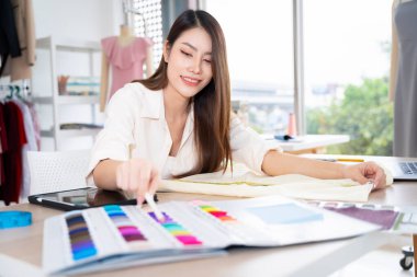 Asian women working together Small business, SME, tailoring designs for customers. Both of them acted as great designers.