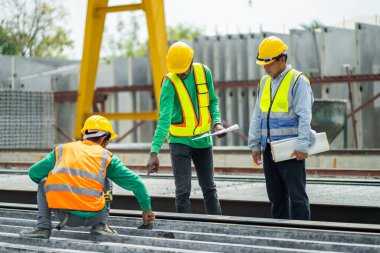 Male engineers are inspecting and controlling the work of the employees and the quality of the manufactured products to meet the standards In industrial factories producing precast prefabricated walls