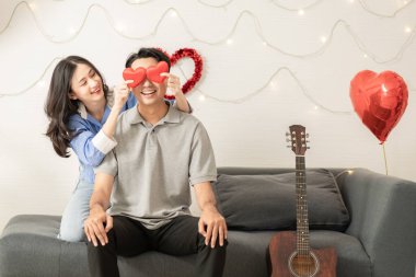 Asian couple Showing love surprise giving flowers or gifts to each other on important occasions such Valentine's Day birthdays or wedding anniversaries with love and warmth in bedroom of their home