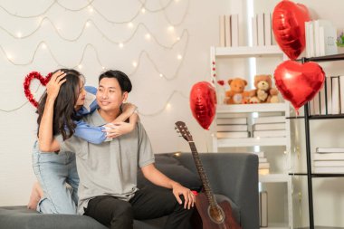 Asian couple Showing love surprise giving flowers or gifts to each other on important occasions such Valentine's Day birthdays or wedding anniversaries with love and warmth in bedroom of their home