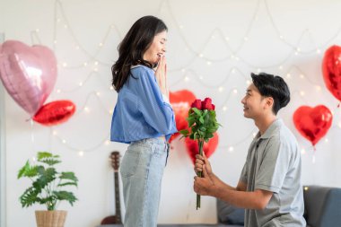 Asian couple Showing love surprise giving flowers or gifts to each other on important occasions such Valentine's Day birthdays or wedding anniversaries with love and warmth in bedroom of their home