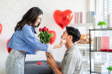 Asian couple Showing love surprise giving flowers or gifts to each other on important occasions such Valentine's Day birthdays or wedding anniversaries with love and warmth in bedroom of their home