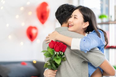 Asian couple Showing love surprise giving flowers or gifts to each other on important occasions such Valentine's Day birthdays or wedding anniversaries with love and warmth in bedroom of their home