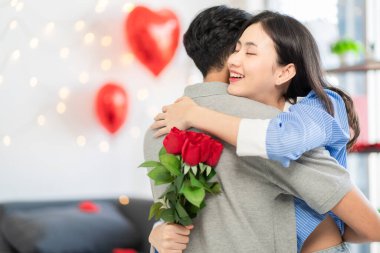 Asian couple Showing love surprise giving flowers or gifts to each other on important occasions such Valentine's Day birthdays or wedding anniversaries with love and warmth in bedroom of their home