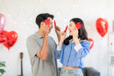 Asian couple Showing love surprise giving flowers or gifts to each other on important occasions such Valentine's Day birthdays or wedding anniversaries with love and warmth in bedroom of their home