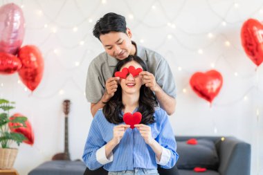 Asian couple Showing love surprise giving flowers or gifts to each other on important occasions such Valentine's Day birthdays or wedding anniversaries with love and warmth in bedroom of their home