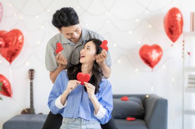 Asian couple Showing love surprise giving flowers or gifts to each other on important occasions such Valentine's Day birthdays or wedding anniversaries with love and warmth in bedroom of their home