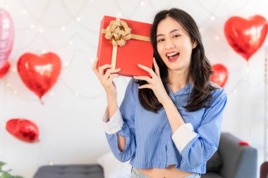 Asian couple Showing love surprise giving flowers or gifts to each other on important occasions such Valentine's Day birthdays or wedding anniversaries with love and warmth in bedroom of their home