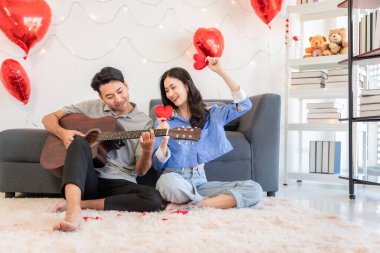 Asian couple Showing love surprise giving flowers or gifts to each other on important occasions such Valentine's Day birthdays or wedding anniversaries with love and warmth in bedroom of their home