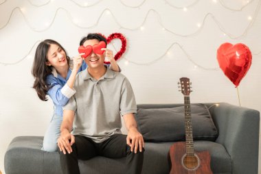 Asian couple Showing love surprise giving flowers or gifts to each other on important occasions such Valentine's Day birthdays or wedding anniversaries with love and warmth in bedroom of their home